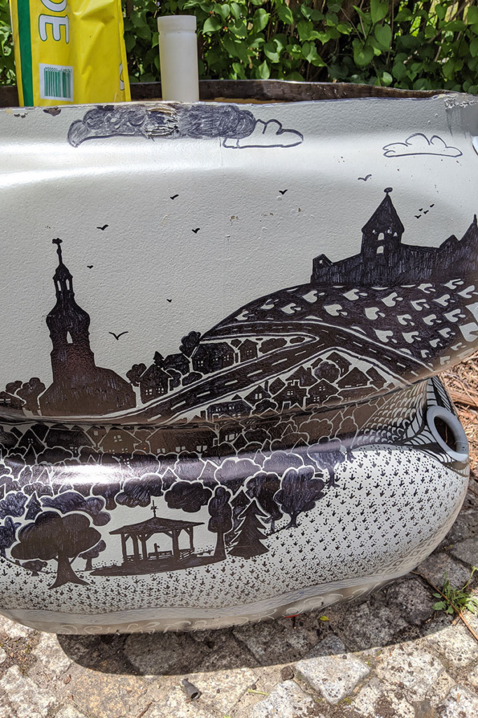 Ein kleines Kunstwerk am Straßenrand zeigt die Burg Hohenberg, die Kirche und die Carolinenquelle